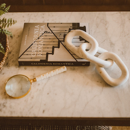 White marble, three link, chain displayed on a coffee table