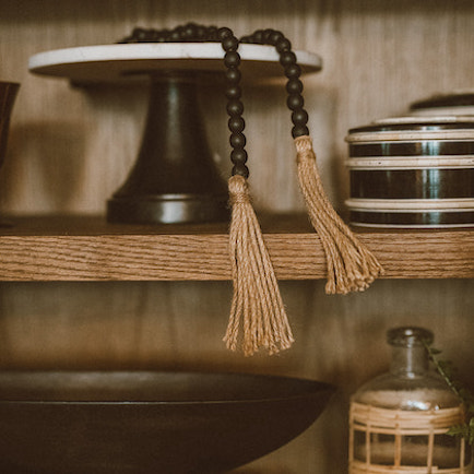 Black wooden beads with Natural jute tassels displayed on shelf