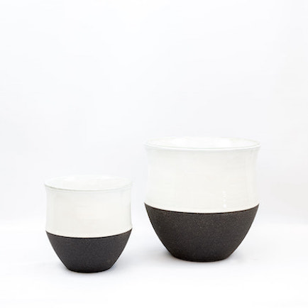 Large and small ceramic pots with lids. White tops, black bottoms