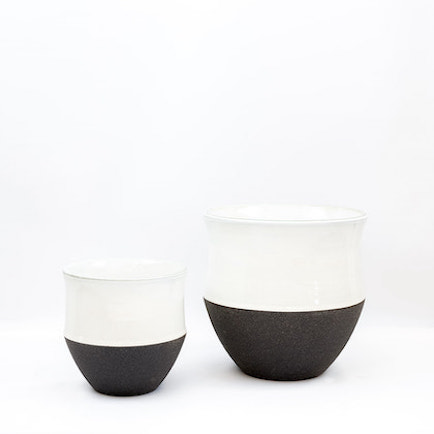 Large and small ceramic pots with lids. White tops, black bottoms