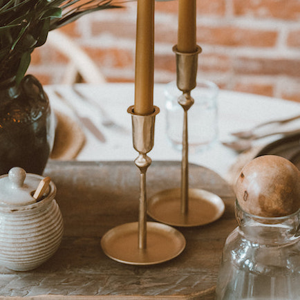 Brass taper candle holder displayed on a dining table