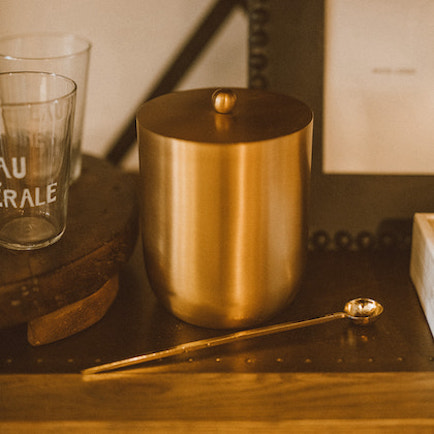 Brass cocktail stirring spoon displayed with bar accessories