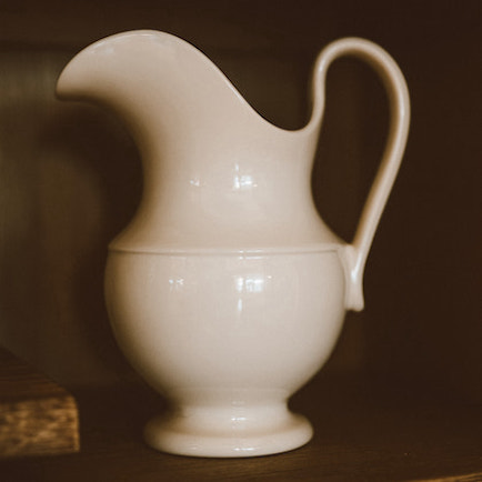 Colonial style stoneware pitcher, double-glazed in cream white. Hand wash only.